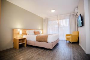蒙得维的亚蓬特鲁维尔酒店的配有一张床和一把椅子的酒店客房