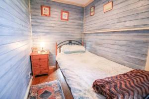 SancreedGranite Country Cottage west of Penzance的一间小卧室,配有一张床和木墙