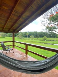 阿瓜斯-迪圣巴巴拉Vale Das Águas Fazenda Resort的门廊上的吊床,享有公园的景致