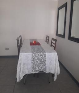 阿里卡Departamento Amoblado en Arica的餐桌、白色桌布和椅子
