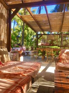 撒尼海滩Sani Villa Haven的庭院设有木凉亭,配有桌椅