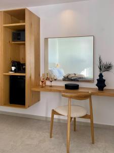米克诺斯城Calistus Mykonos的客房设有带镜子和椅子的书桌
