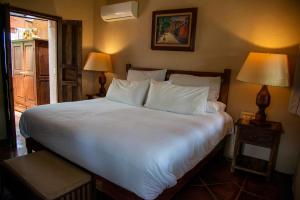 圣米格尔-德阿连德尼凡娜餐厅加疗养酒店的一间卧室配有一张带两盏灯的大型白色床。