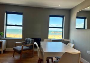 KentBeachfront Bliss Margate With Sea Views Sleeps 7的一间带桌椅的海景用餐室