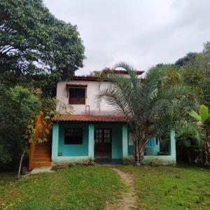 帕尔梅拉斯Casa Quaresmeira的前面有棕榈树的房子