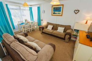 克罗伊德CROYDE SEA BREEZE 3 Bedrooms的客厅配有两张沙发和一张桌子