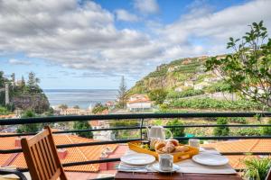 蓬他达维托亚Lidia's Place, a Home in Madeira的阳台上的餐桌和食物