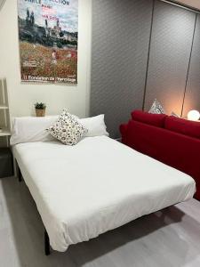 MatadeperaAlojamiento privado en casa de montaña的一张大白色的床,位于一个红色沙发的房间