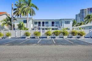 好莱坞Waves On Desoto 1- Bedroom Rental Unit With Pool的停车场内有棕榈树的白色围栏