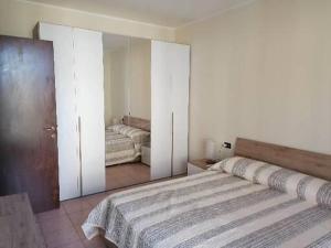CastellaroCasa Laghetto的一间卧室配有一张大床和镜子