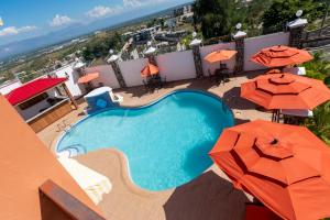 太子港Vivy Hill's Hotel的享有带遮阳伞的游泳池的顶部景致
