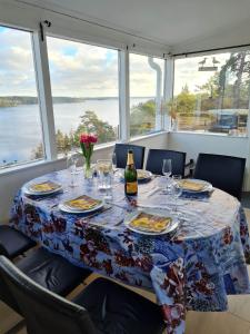 TyresöArchipelago villa, cabin & sauna jacuzzi with sea view, 30 minutes from Stockholm的餐桌,带食物盘和一瓶葡萄酒