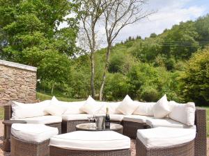 利德尼Perivale Lodge的庭院配有白色的沙发、桌子和椅子