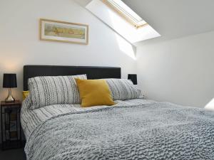 利德尼Perivale Lodge的一间卧室配有一张黄色枕头的床