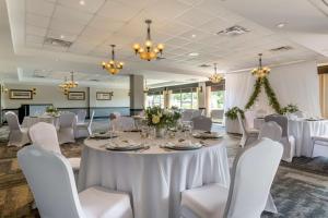 哈利法克斯哈利法克斯巧克力湖贝斯特韦斯特优质酒店的宴会厅配有白色的桌椅和吊灯。