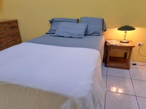 圣克里斯托瓦尔Casa Itabaca I的一间卧室配有一张床和一张带台灯的桌子