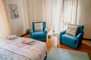 El FigaróCasa les Pomeretes的一间卧室配有2把蓝色椅子和1张床