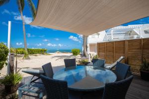 圣马丁岛Modern Beach Villa 1150的海滩上带桌椅的天井