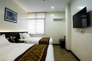卡加盐德奥罗PRIMELUXE HOTEL的酒店客房设有两张床和一台平面电视。
