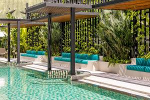 苏林海滩Outrigger Surin Beach Resort - SHA Extra Plus的游泳池旁的游泳池配有蓝色躺椅