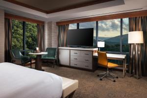 萨拉曼卡Seneca Allegany Resort & Casino的酒店客房配有一张床和一张书桌及一台电视