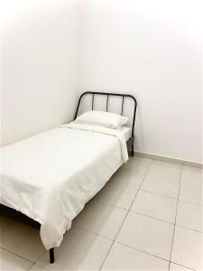 实达阿南Melur Homestay的白色墙壁间的一张床位