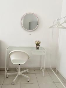 实达阿南Melur Homestay的白色的书桌、白色的椅子和镜子