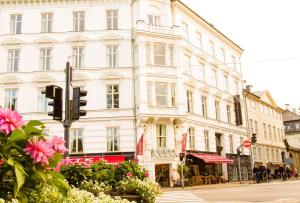 哥本哈根巴贝特古尔德斯梅登酒店的一条城市街道上一座白色的大建筑,有交通灯