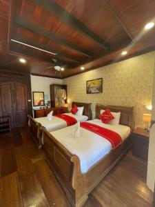 琅勃拉邦Luang Prabang Villa Sirikili River View的一间卧室配有两张带红色枕头的床