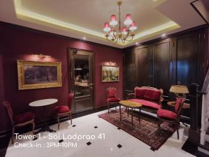 曼谷Double Bed Hotel的一间设有红色椅子、一张桌子和吊灯的房间
