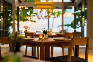 蔻立Outrigger Khao Lak Beach Resort - SHA Extra Plus的餐厅的木桌,上面有蜡烛