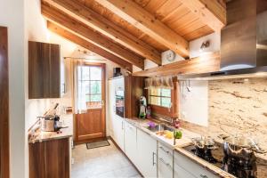 采尔马特海因特德姆罗特斯木屋的大型厨房设有木制天花板和木制柜台。