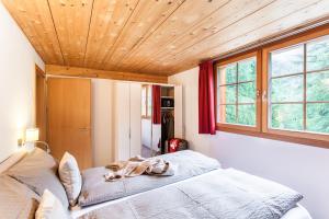 采尔马特海因特德姆罗特斯木屋的一间卧室设有一张床和木制天花板