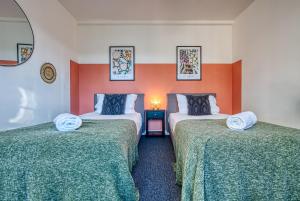 赛伦塞斯特Brewery Loft - 3 Bedroom Bright Spacious apartment in the centre of town, Wifi, Netflix的橙色和白色墙壁的客房内的两张床