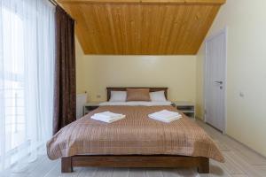 布克维Шепіт Лісу的一间卧室设有一张带木制天花板的大床