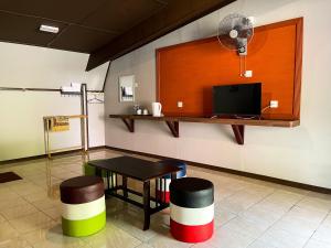 拉瑙SUNRISE RECREATION HOMESTAY & CHALET的一间设有一张桌子、两张凳子和一台电视的房间