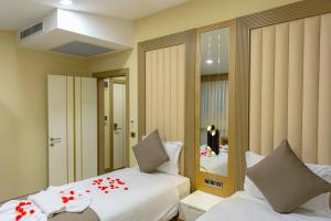 伊斯坦布尔BRAKO HOTEL的一间卧室配有两张床和镜子