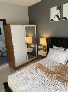 BijiloAminah’s Space - Jobz Luxury Rental的一间卧室配有一张带两盏灯和两面镜子的床。