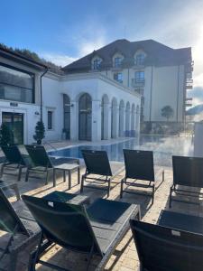 克利默内什蒂RIVER Hotel & SPA的一组椅子坐在游泳池旁