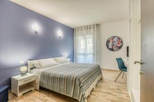 特尔尼Asso Residence的一间卧室设有一张床和蓝色的墙壁