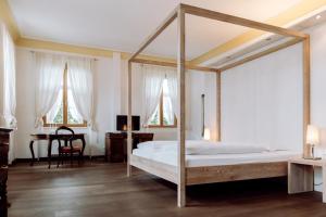 RiederingHirzinger - Gasthaus und Hotel的一间卧室配有一张天蓬床和一张书桌