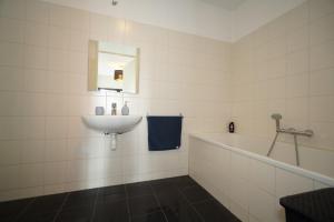 鹿特丹CityView Apartment including parking的白色的浴室设有水槽和浴缸。