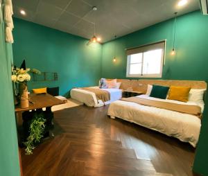恒春古城麋宿Mi House墾丁包棟的一间设有两张床和绿色墙壁的客房