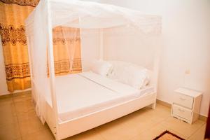 鲁亨盖里Leisure Safaris and Inns的客房内的白色床和天蓬