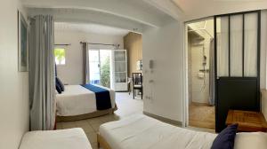 雷岛林滩La Villa - Hôtel Bien Être的酒店客房带两张床和一间浴室