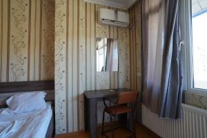 库塔伊西imperator 1 Hotel的一间卧室配有书桌、床和窗户。