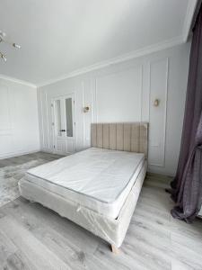 阿斯塔纳Premium Apartments Esil Riverside的一间白色客房内的床铺卧室