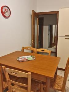 卡奥莱Casa Comisso的厨房配有木桌、椅子和冰箱