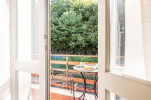 卢卡Appartamento Poggio del Sole的玻璃门通向带桌子的庭院