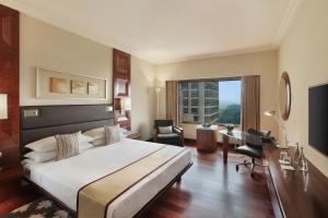 新德里新德里凯悦酒店 的酒店客房设有一张大床和一张书桌。